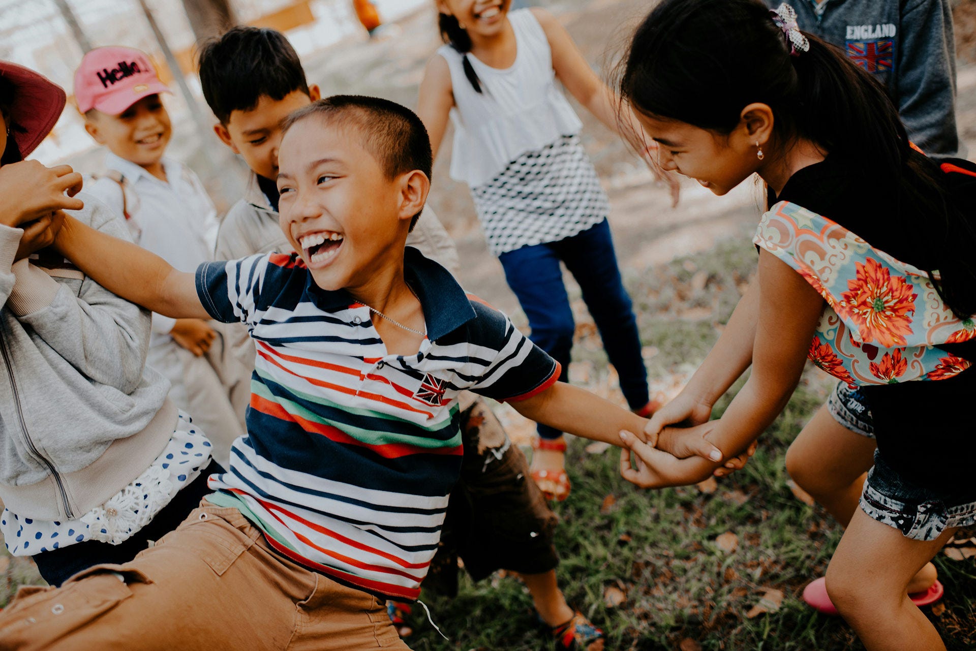 Children playing and laughing together outdoors during an active play activity.