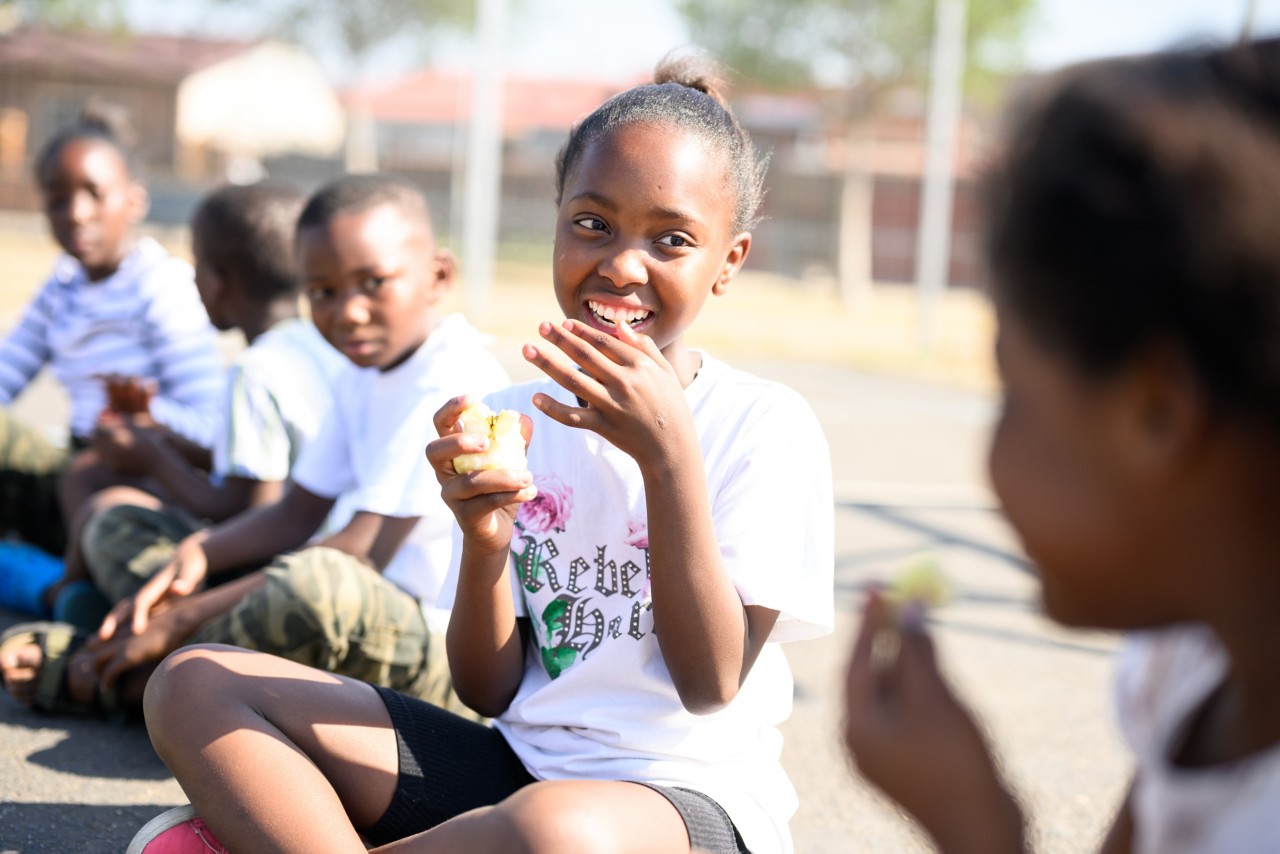 Children playing, eating fruit, socially disadvantaged neighbourhood